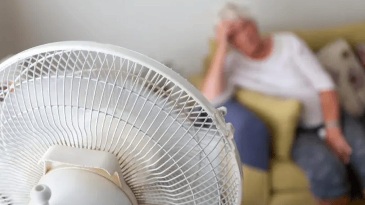 Personas protegiéndose del calor extremo en una calle bajo el sol intenso, representando la crisis sanitaria por altas temperaturas