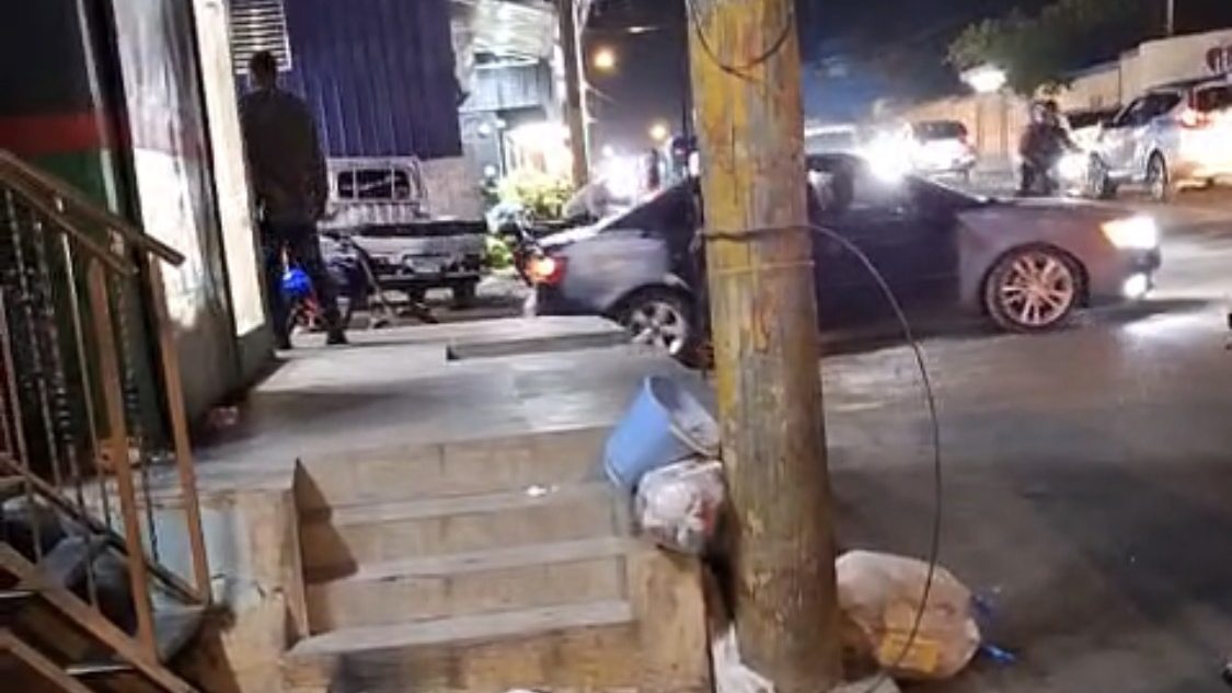Escalera de colmado ocupando la acera en la Carretera Mella, Santo Domingo Este, bloqueando el paso a peatones