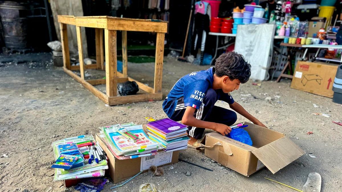 Niños palestinos sentados en colchonetas dentro de una tienda de campaña habilitada como aula en la Franja de Gaza