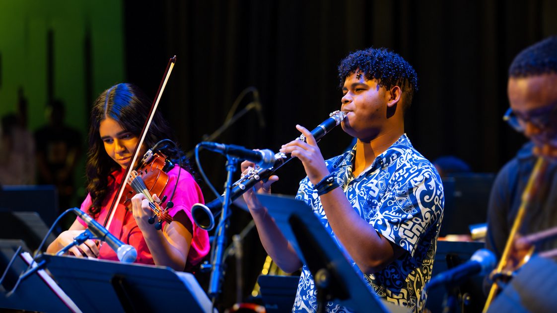 Jóvenes músicos dominicanos tocando instrumentos en un taller de música en Santo Domingo