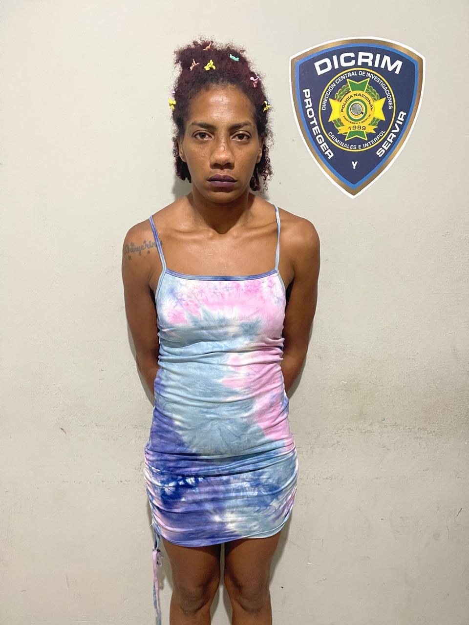 Agentes de la Policía Nacional custodian a una mujer detenida en Santiago por robo de dinero