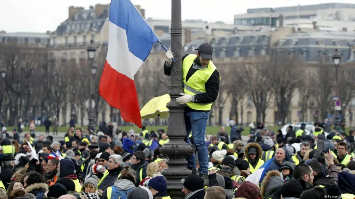 Manifestantes con chalecos amarillos frente a barricadas en llamas en París el 17 de octubre de 2026