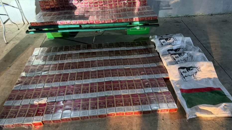 Agentes de la Policía Nacional junto a sacos con cigarrillos ocupados en vivienda abandonada de Capotillo, Distrito Nacional