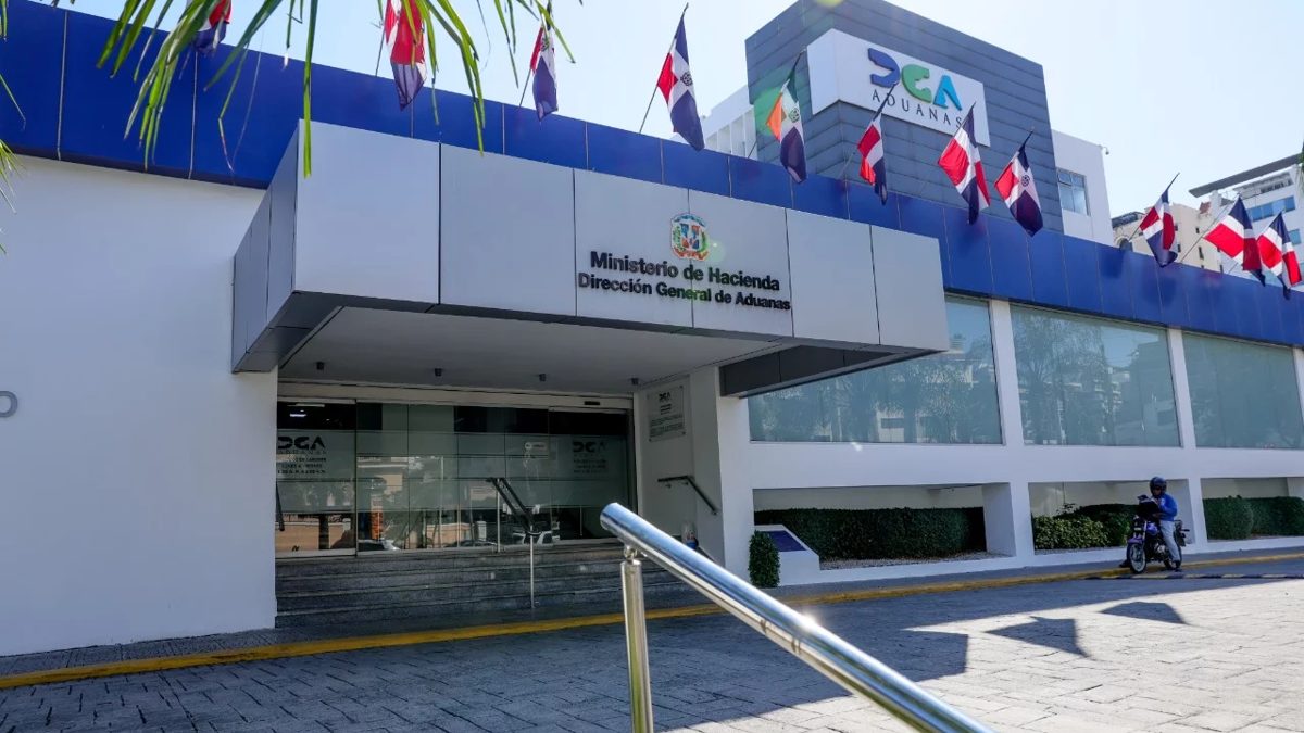 Agentes de la DGA junto a cajas de cigarrillos y televisores decomisados en contenedores en República Dominicana