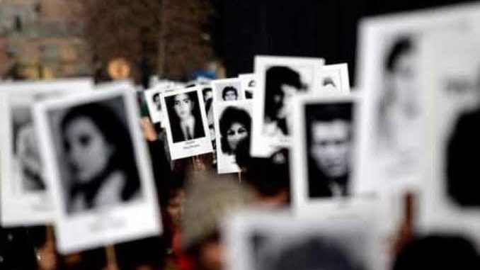 Familiares de personas desaparecidas sosteniendo fotografías durante conmemoración del Día Internacional de las Víctimas de Desapariciones Forzadas