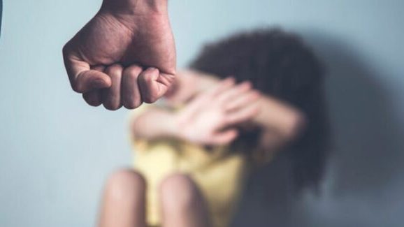 Niño dominicano con gesto de protección ante un adulto, ilustrando el castigo físico en el hogar