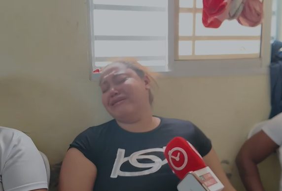 Familiares llorando y abrazados durante el velatorio del joven baloncestista en Villa Altagracia