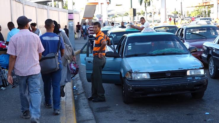 Surtidor de gasolina y pollo fresco en supermercado dominicano reflejando el alza de precios en junio