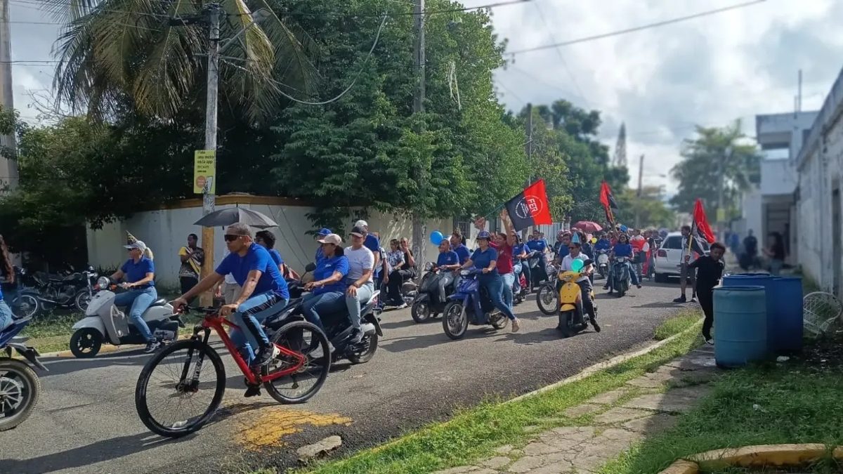 Maestros y padres marchando en el sector Los Rieles de San Francisco de Macorís frente a escuela deteriorada