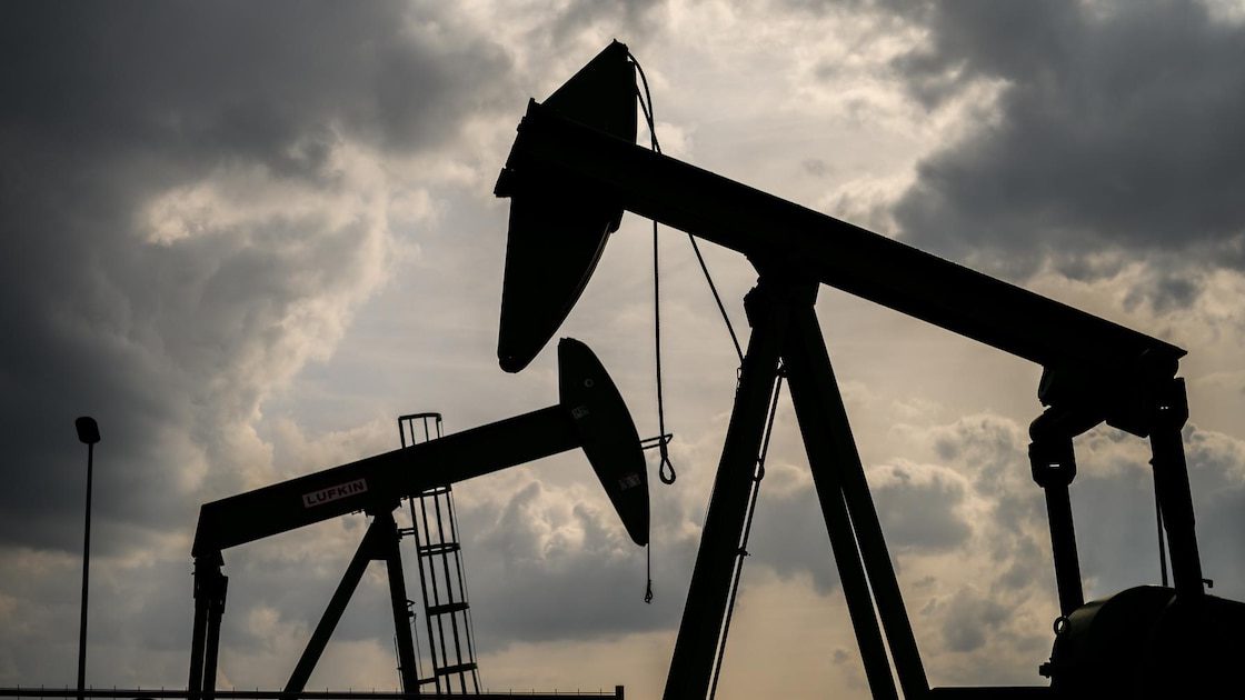 Buque petrolero navegando cerca del estrecho de Ormuz con instalaciones petroleras al fondo