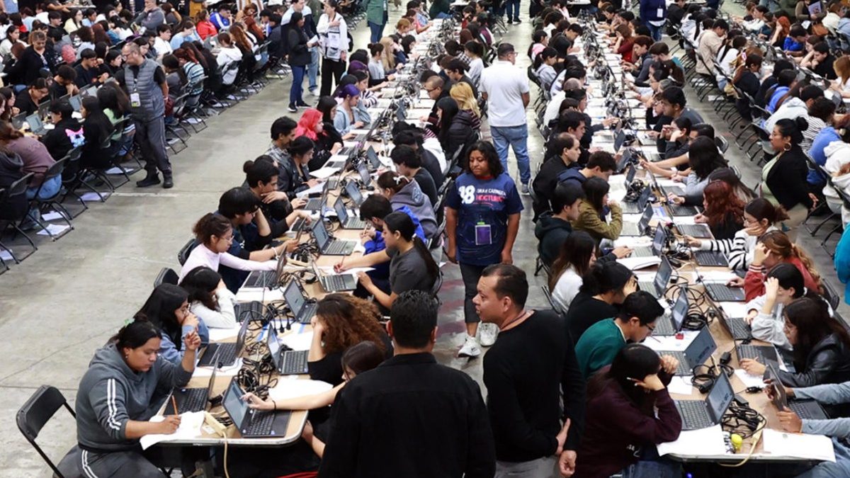 Aspirantes haciendo fila en el Palacio de los Deportes de Ciudad de México para presentar el examen presencial de admisión a la UNAM