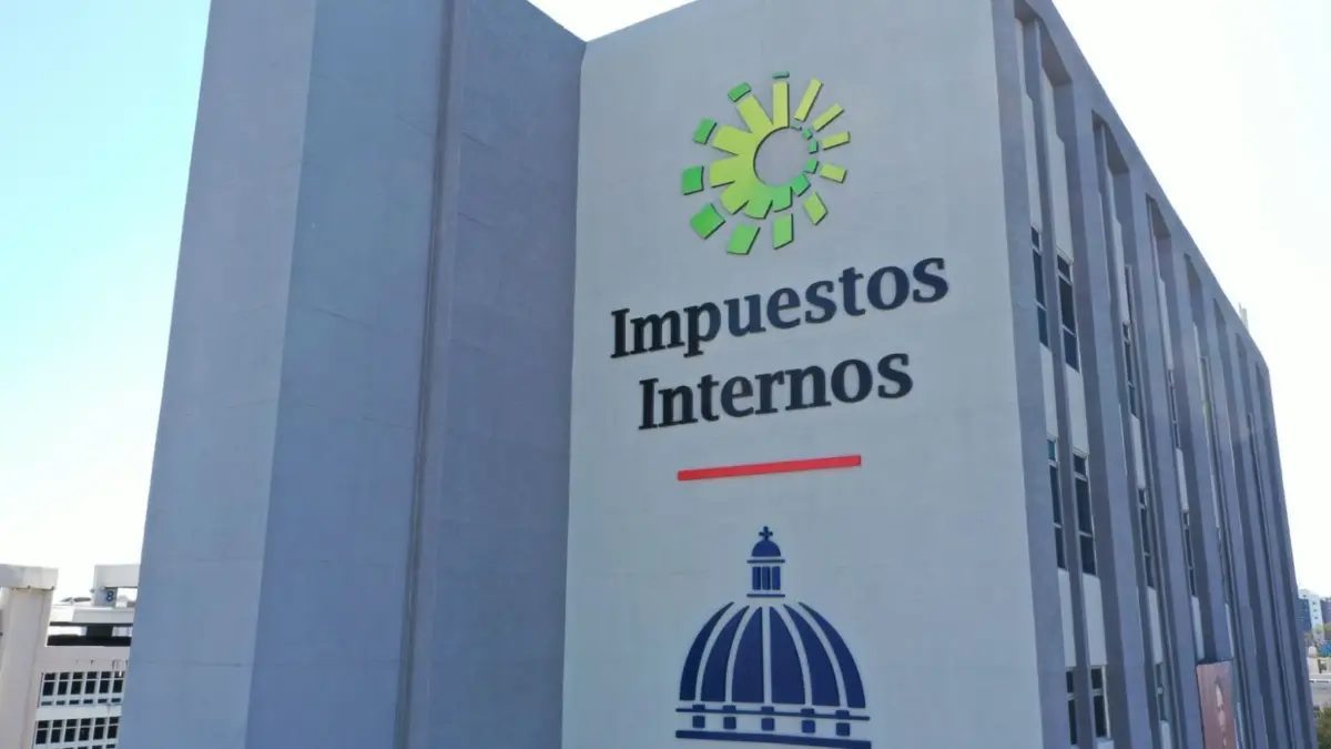 Empresario dominicano revisando factura electrónica e-CF en pantalla de computadora en oficina