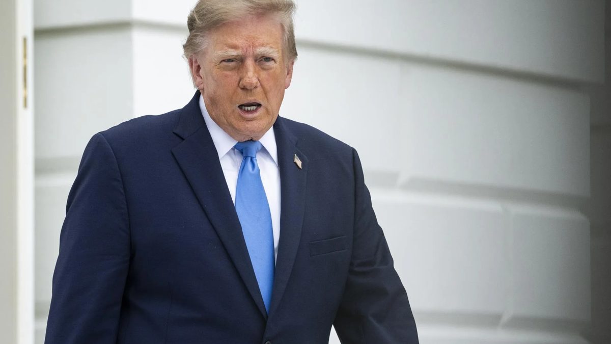 Donald Trump firmando documentos en la Casa Blanca rodeado de funcionarios durante anuncio sobre inteligencia artificial