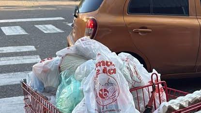 Fundas plásticas de un solo uso apiladas en mostrador de supermercado dominicano