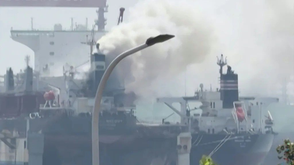 Buque de carga Ocean Melody con humareda en astillero de Qingdao, China, rodeado de camiones de bomberos