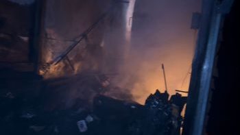 Bomberos y autoridades frente a locales destruidos por incendio en el Mercado Modelo de Santiago, calle Del Sol