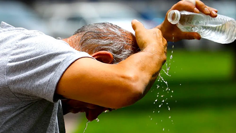 Personas bajo el sol intenso en una calle de Santo Domingo durante ola de calor en República Dominicana