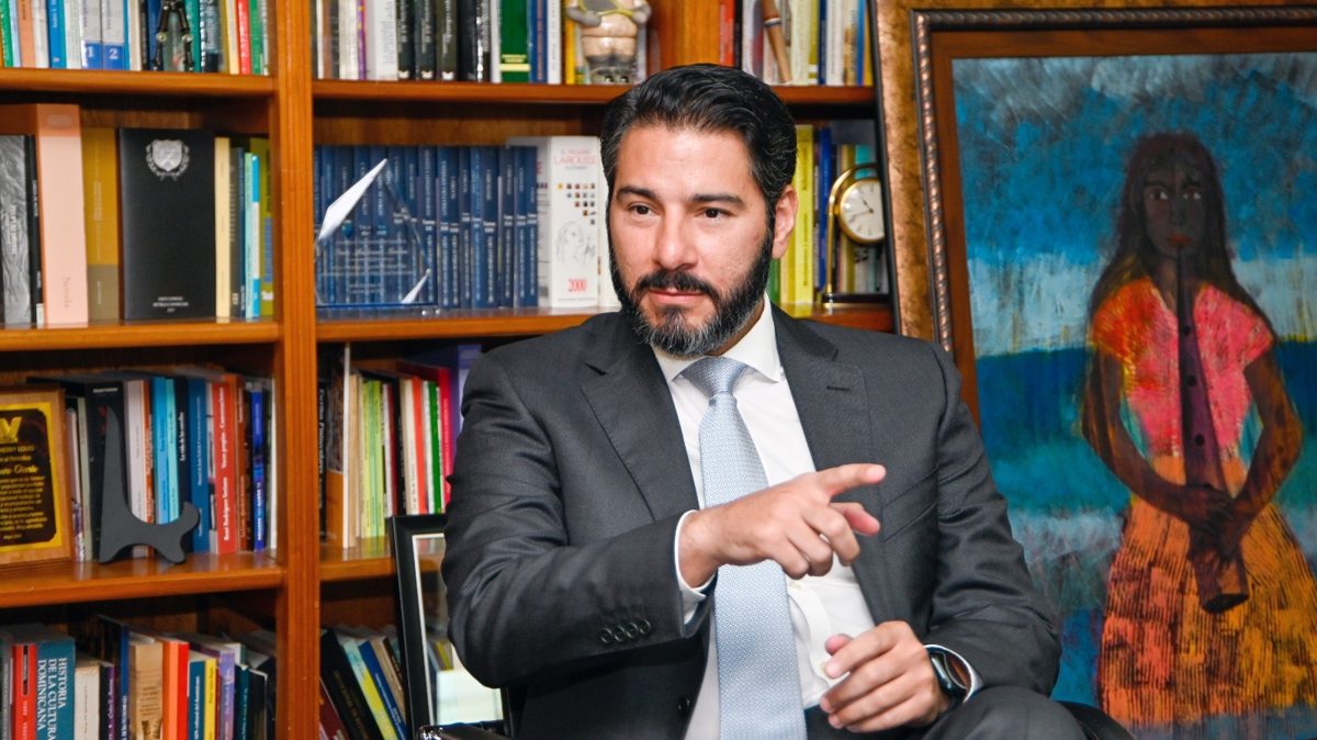 Trabajador dominicano revisando documentos de su cuenta de pensiones frente a una computadora