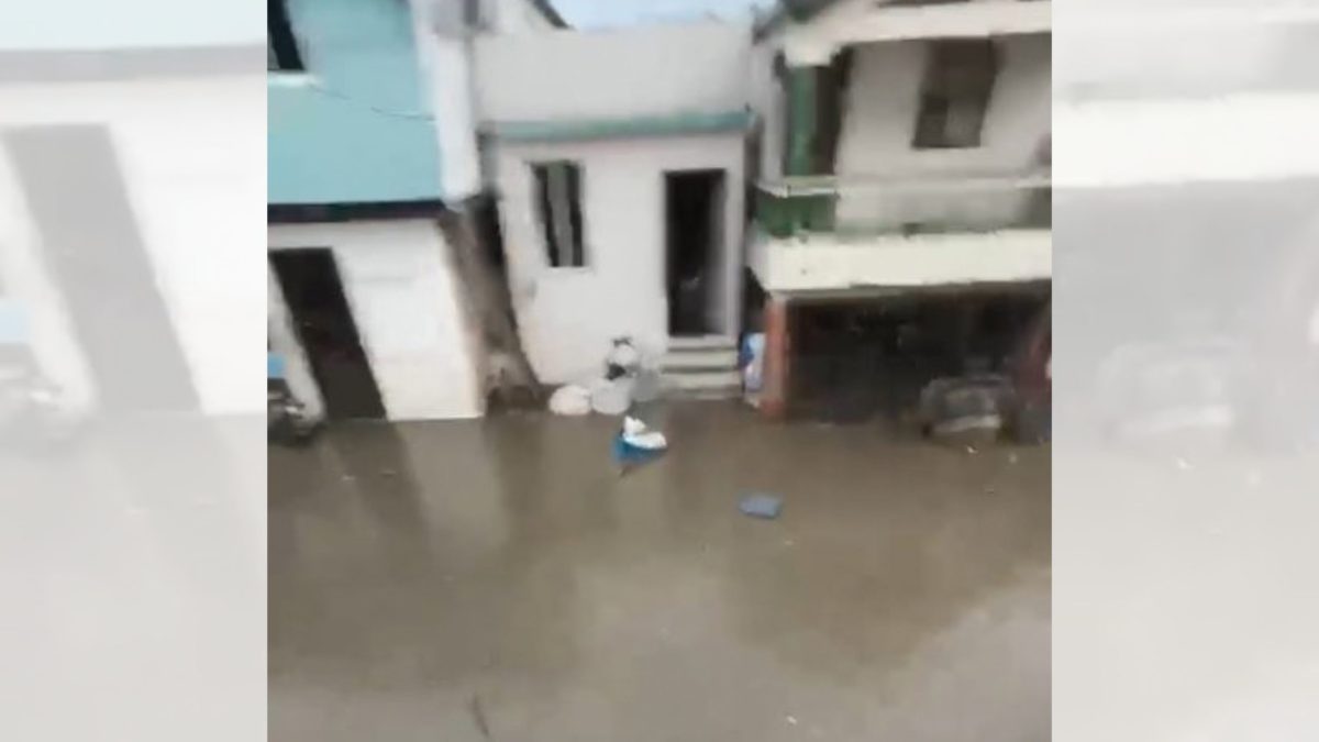 Calle inundada en Santiago Oeste durante lluvias con agua cubriendo la calzada en sector urbano