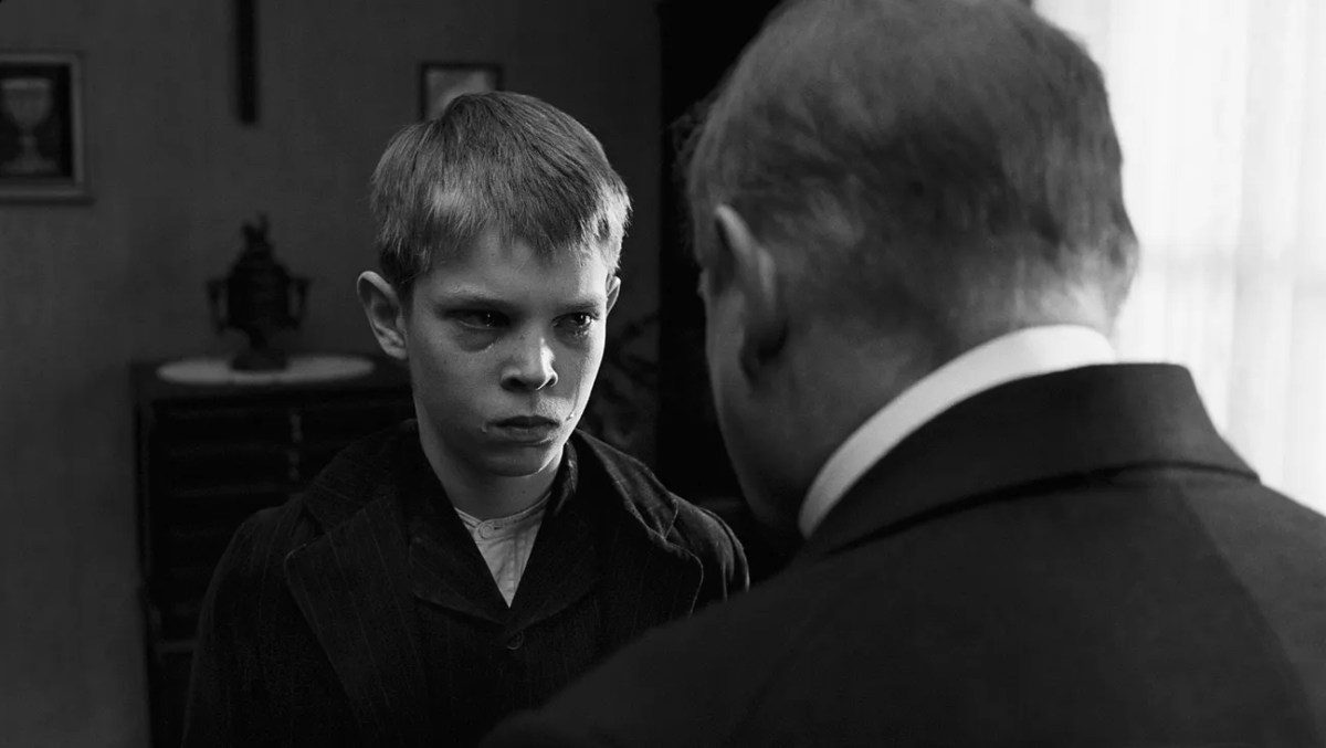 Escena en blanco y negro de La cinta blanca de Michael Haneke con niños en un pueblo alemán de 1913