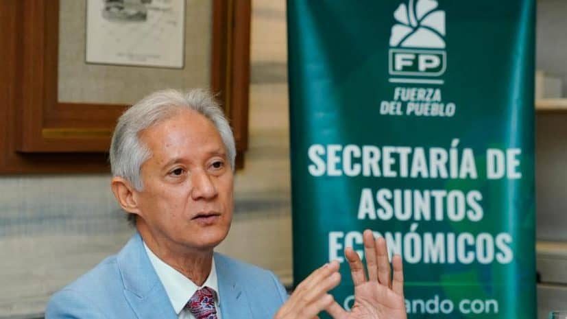 Conductor pagando en una estación de combustible en República Dominicana mientras muestra su marbete vehicular
