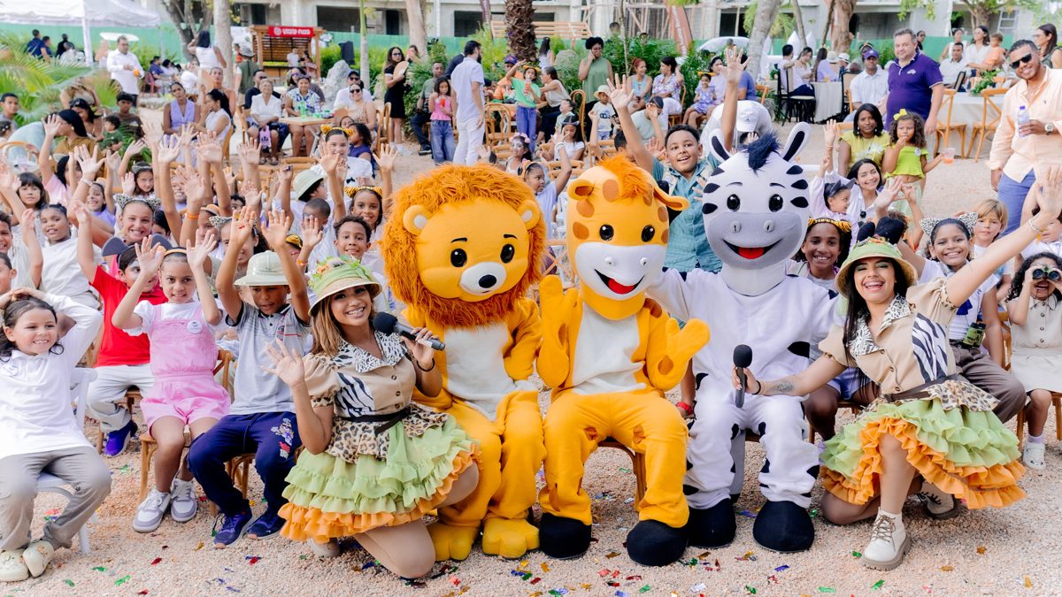 Animadores disfrazados de safari y mascotas de león, jirafa y cebra posan con niños que agitan las manos durante el Verano