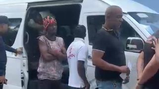 Agentes de la Policía Nacional junto a un autobús blanco detenido en la Autopista Duarte, Bonao, tras operativo contra traslado de migrantes