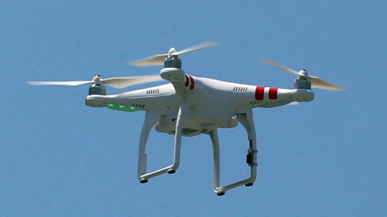 Drone volando sobre un estadio deportivo con letrero de restricción en Santo Domingo