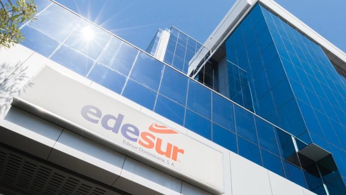 Paneles solares instalados en techo de vivienda dominicana con postes de electricidad de Edesur al fondo