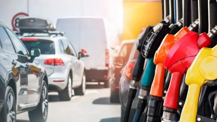 Empleado en una gasolinera dominicana sirviendo combustible a un vehículo durante la semana de precios congelados