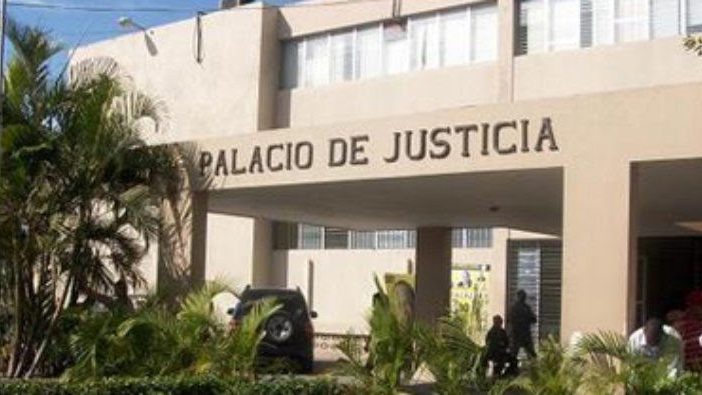Comunitarios con pancartas protestan frente al Palacio de Justicia de Azua exigiendo libertad de imputado