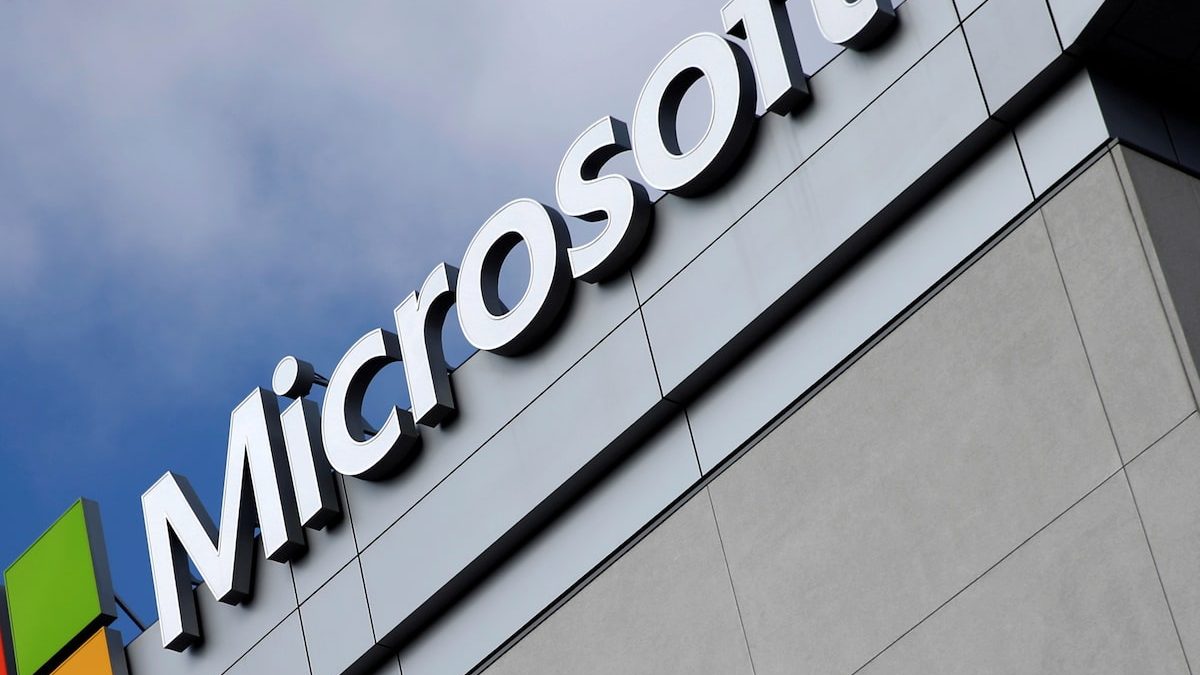 Sede corporativa de Microsoft con logo iluminado y trabajadores transitando por el campus