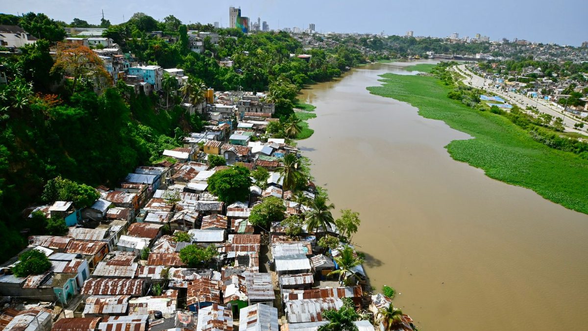 Riberas del río Ozama en Santo Domingo Este con nivel de agua elevado y viviendas cercanas en zona de riesgo