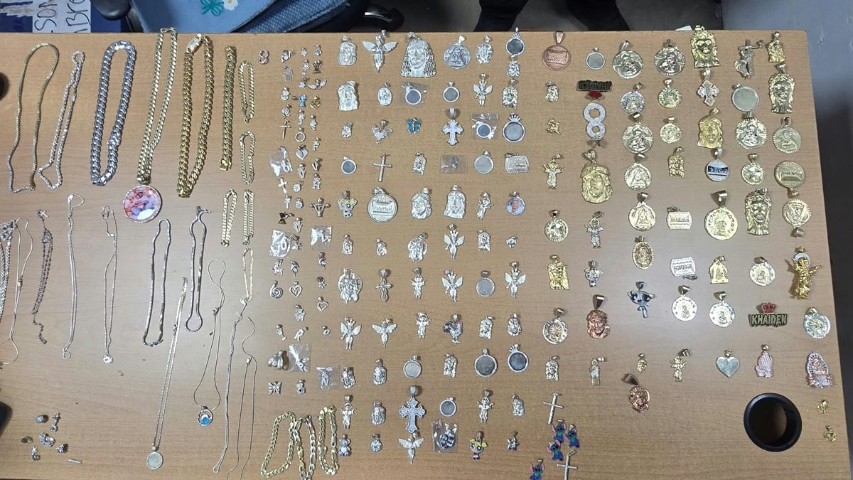 Agentes de la Policía Nacional junto a prendas de oro y plata recuperadas tras robo a joyería en Santiago