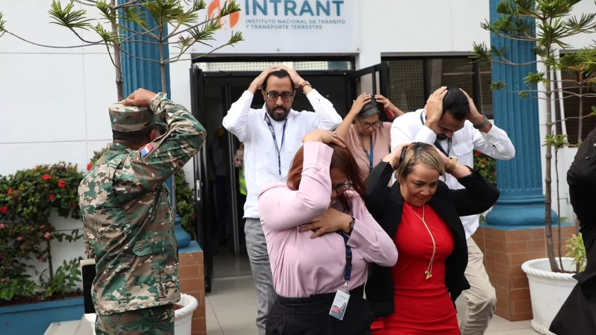 Empleados del INTRANT evacuando sus instalaciones durante el simulacro nacional de terremoto coordinado por el COE en Santo Domingo