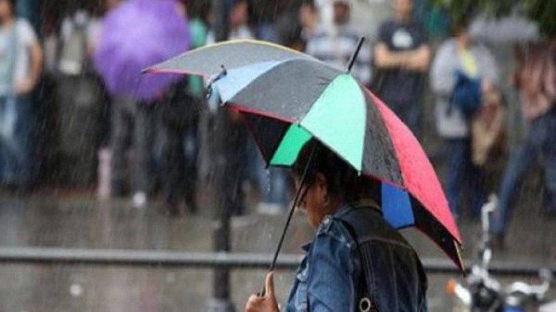 Estudiantes frente a un centro educativo cerrado bajo lluvia intensa en Santo Domingo, República Dominicana