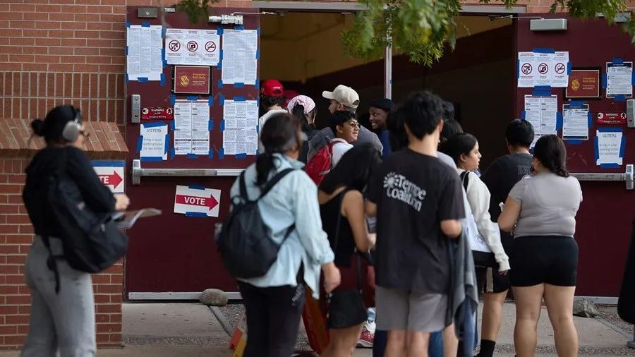 Estudiantes universitarios extranjeros graduados frente a la bandera de Estados Unidos