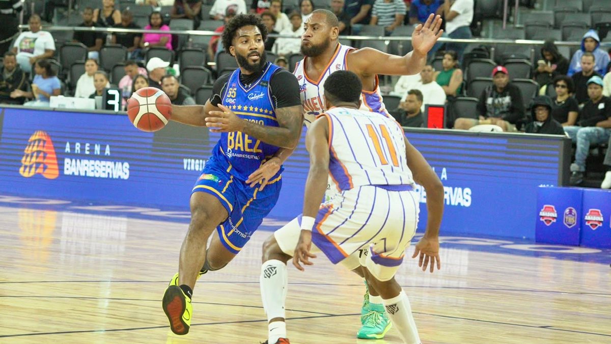 Jhery Matos del Mauricio Báez avanza con el balón ante la defensa de Maevin Smith Jr. del club Huellas del Siglo en el TBS Distrito 2026