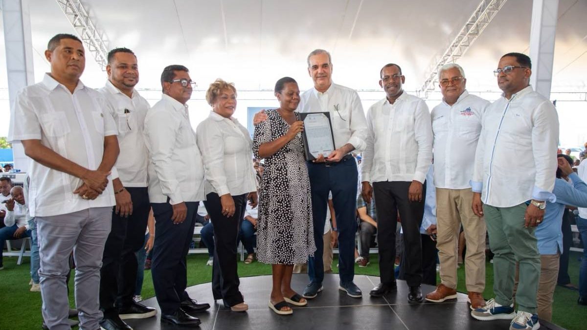 Presidente Abinader entregando certificados de títulos de propiedad a familias de Los Alcarrizos en acto comunitario
