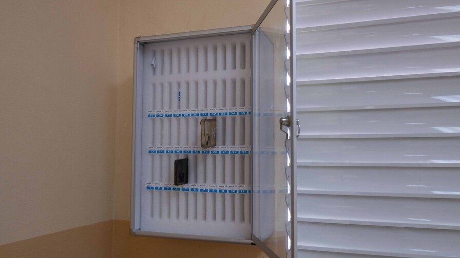 Estudiantes de secundaria entregando sus celulares en una caja al inicio de la jornada escolar en un colegio de Santo Domingo
