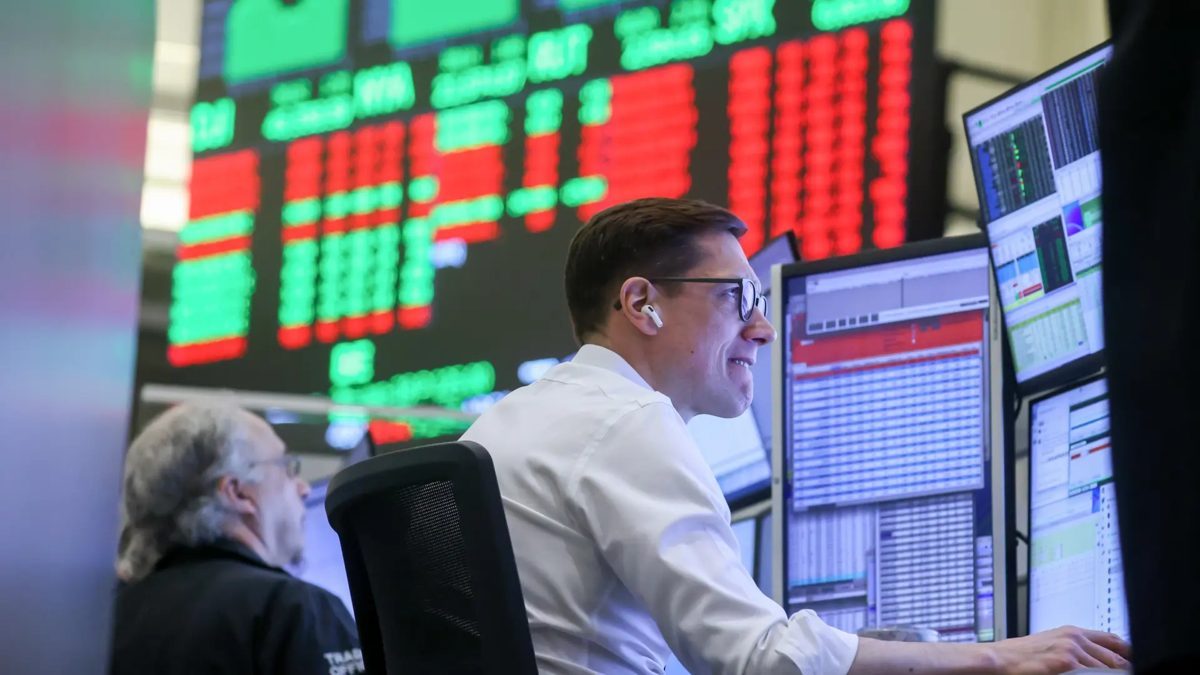 Pantallas del mercado de valores mostrando caídas en el Nasdaq y alza en rendimientos de bonos globales